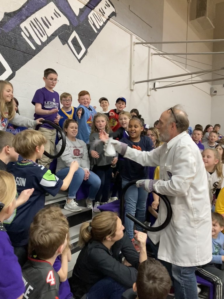 scientist with students gathered around a beaker